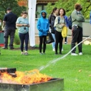 A woman extinguishes a fire during the 2022 Fall Safety Fair.