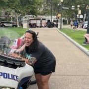 A woman laughs as a boy activates the siren on a University of Pittsburgh Police motorcycle.